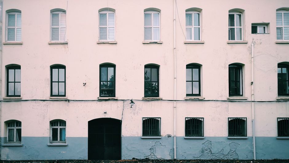 The front of an older building with evenly spaced windows.